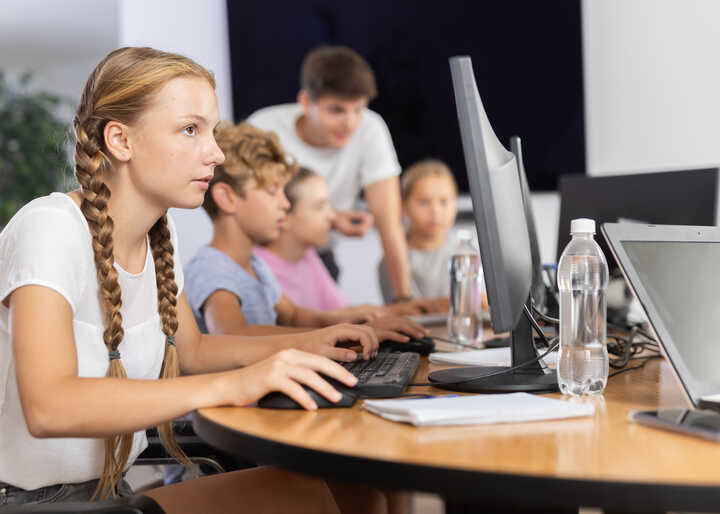 Group of students working on computers in a classroom setting.
