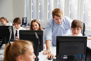 students and teacher sat with a laptop students and teacher sat with a laptop