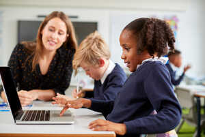 teacher and young students with laptop
