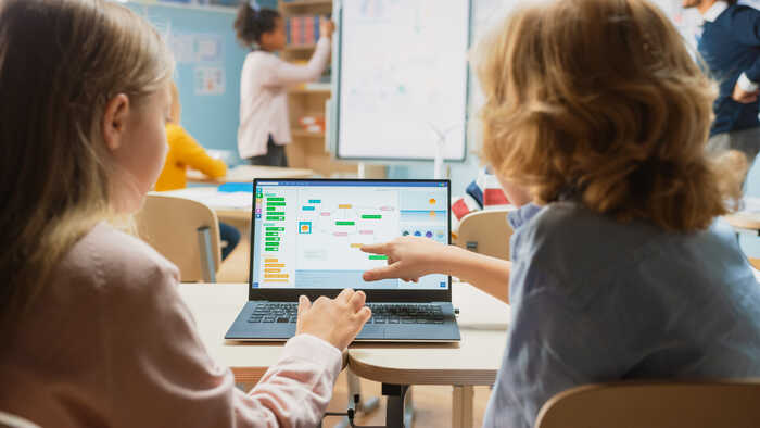 children using a laptop in a classroom
