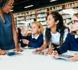 teachers working with students on a tablet