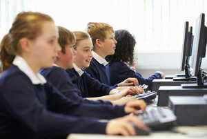 Students focused at computers in a classroom setting.