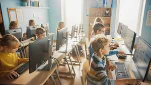Students using computers in a brightly lit classroom.
