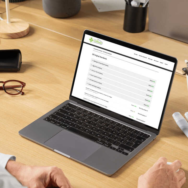 Students working together at computers, smiling and engaging in a classroom setting.