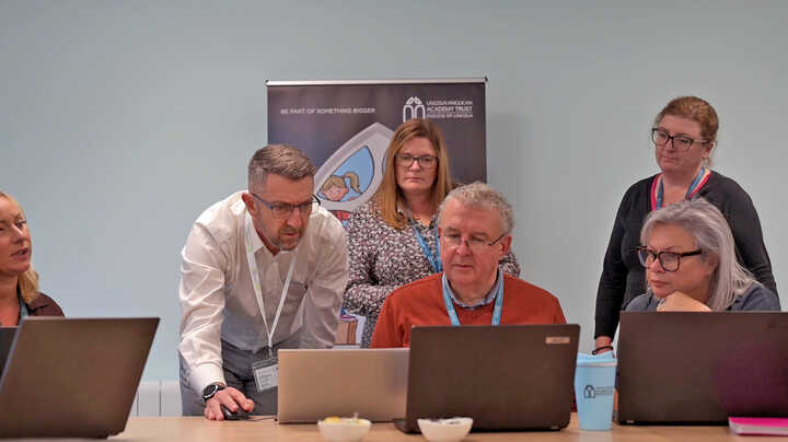 A Learning Locker staff training session is taking place around laptops in a meeting room. 