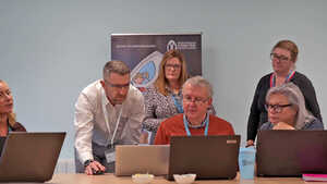 A Learning Locker staff training session is taking place around laptops in a meeting room.