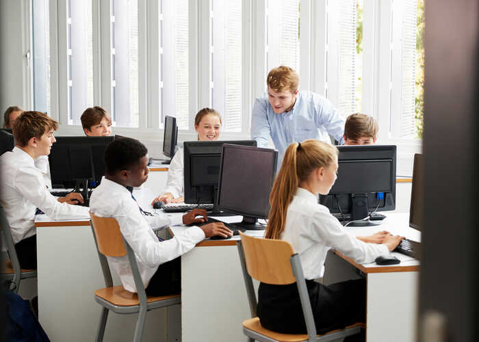 teacher helping students with IT work teacher helping students with IT work