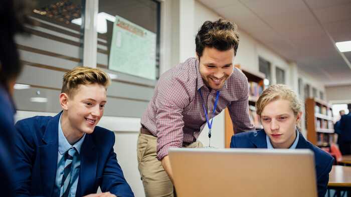 teacher helping students with IT work teacher helping students with IT work