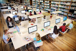 teachers working with students on desktop computers teachers working with students on desktop computers